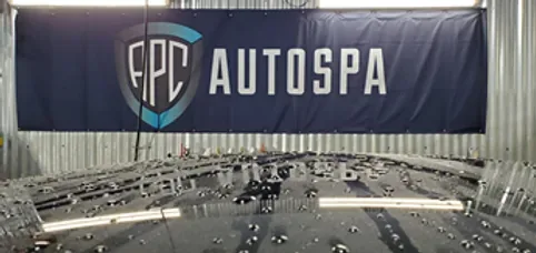APC Auto Spa banner above a water-beaded vehicle in the shop